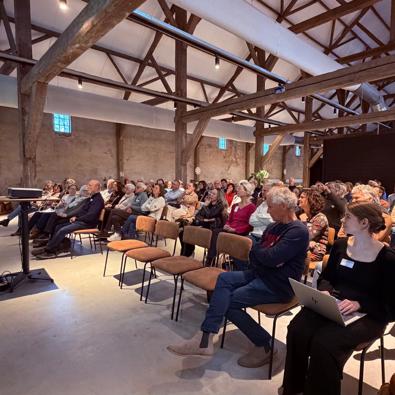 Deelnemers in de zaal tijdens bijeenkomst
