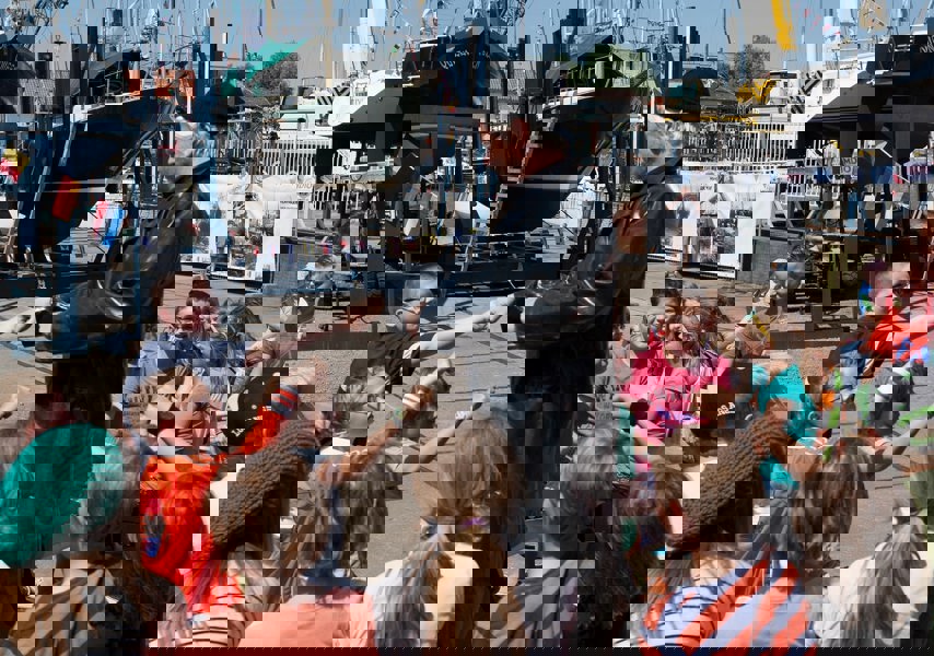 Man die verkleed is met groep kinderen om hem heen