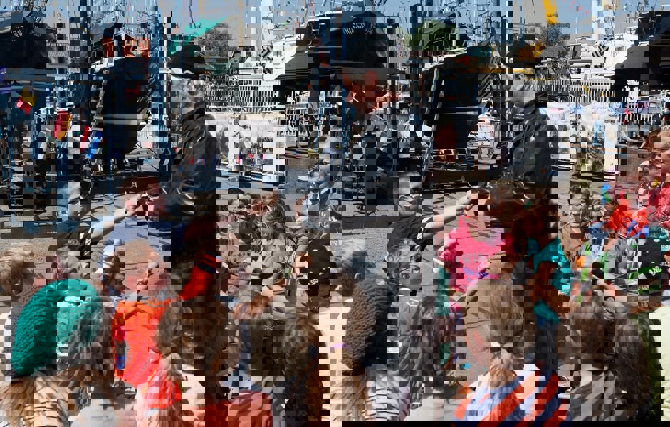 Man die verkleed is met groep kinderen om hem heen