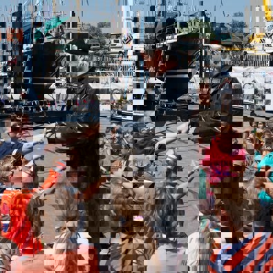 Man die verkleed is met groep kinderen om hem heen