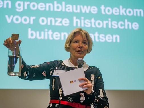 Gedeputeerde van Zuid-Holland Willy de Zoete houdt fles met water in de lucht (Foto: Kennisprogramma Klimaatrobuuste Buitenplaatsen)