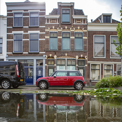 Auto staat aan de kade met hoog water
