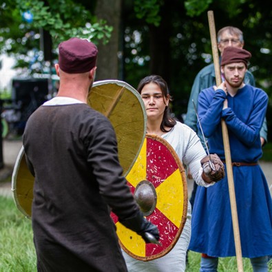 Re-enactment met jongeren die zwaardvechten met schild in hand