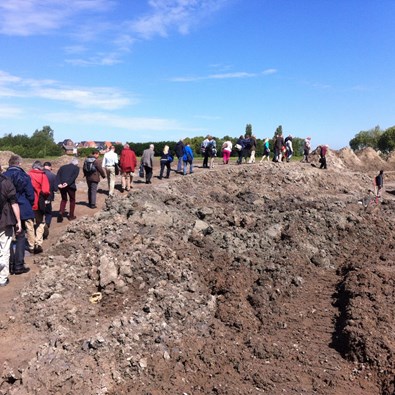 Groep mensen loopt langs archeologische opgraving