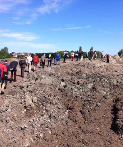 Groep mensen loopt langs archeologische opgraving
