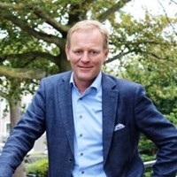 man lacht naar de camera