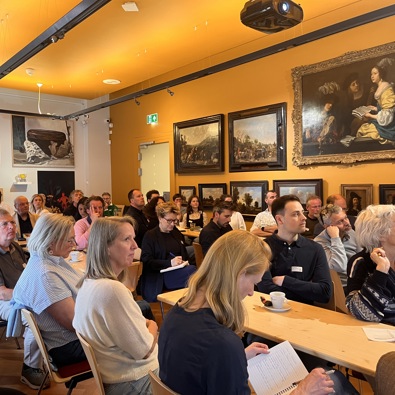 zaal vol publiek tijdens bijeenkomst
