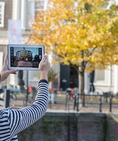Vrouw maakt foto met tablet in de stad