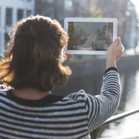 Vrouw maakt foto met tablet in de stad