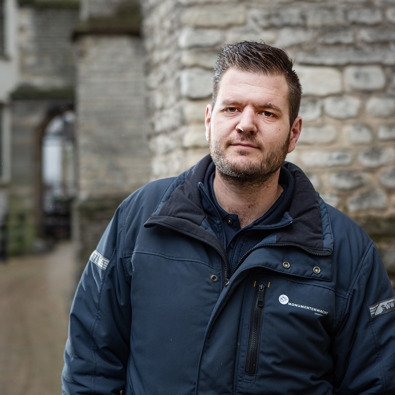 portretfoto van monumentenwachter naast monument