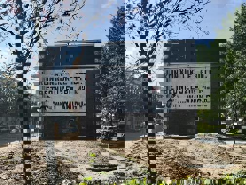 Zijaanzicht van villa Waning met promotietekst op muur