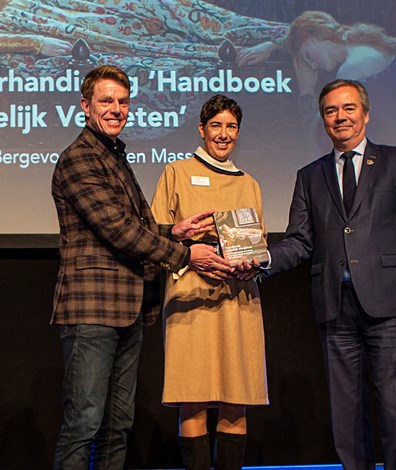 Evelien Masselink en Frank Bergevoet reiken het eerste exemplaar van Handboek Ordelijk Vergeten uit aan gedeputeerde Meindert Stolk. Foto: Floris Scheplitz