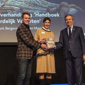 Evelien Masselink en Frank Bergevoet reiken het eerste exemplaar van Handboek Ordelijk Vergeten uit aan gedeputeerde Meindert Stolk. Foto: Floris Scheplitz