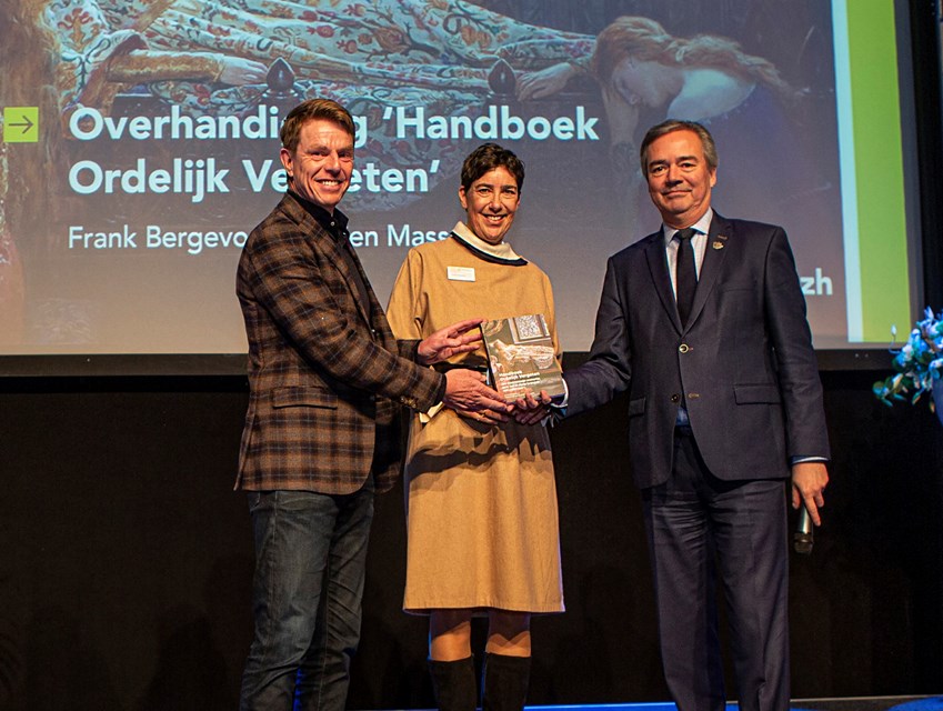 Overhandiging van het boek. V.l.n.r.: Frank Bergevoet, Evelien Masselink en Meindert Stolk. Foto: Floris Scheplitz.