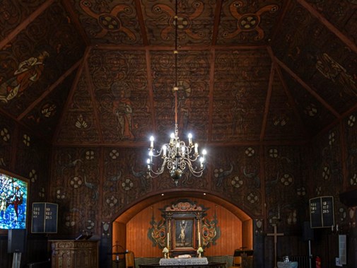 Op de houten wanden en het plafond bevinden zich muurschilderingen in warme aardse tinten (Foto: Floris Scheplitz).