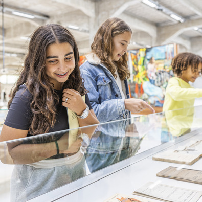 Kinderen kijken naar een vitrine met objecten in het FENIX-museum