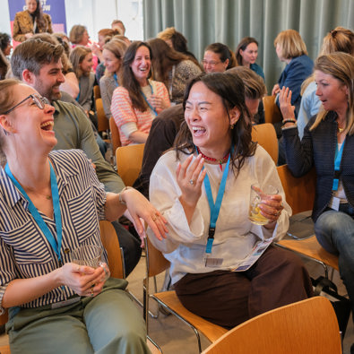 Groep deelnemers die elkaar lachend aankijken
