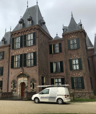Busje van de monumentenwacht staat geparkeerd voor een kasteel tijdens de inspectie