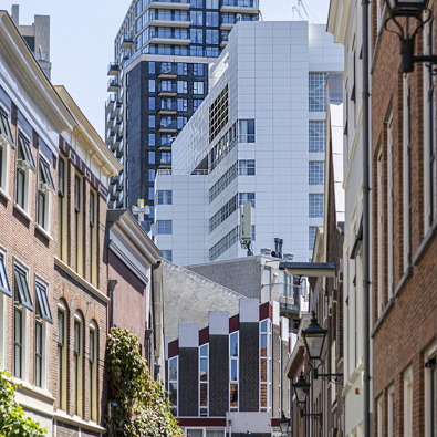 overzichtsfoto van straat met oude gevels met op de achtergrond hoge torenflats
