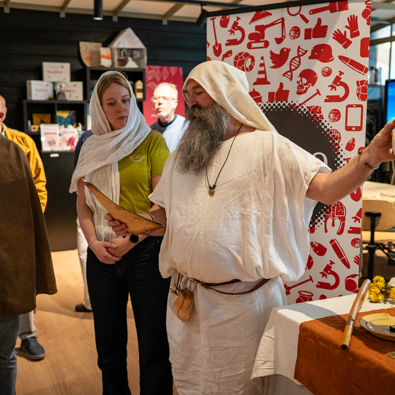 priester doet plengoffer bij de opening van het archeolab