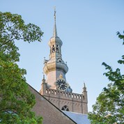 Kerktoren met spits dak en grote klok