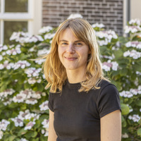 Portretfoto Maike Brinkman met op achtergrond bloemen