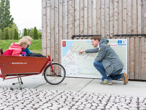 Vader en twee kinderen naast overzichtskaart bij limeslocatie Park Matilo in Leiden (Foto: Floris Scheplitz / Erfgoedhuis Zuid-Holland)