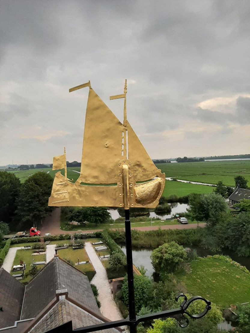 Gouden windwijzer in de vorm van een schip.