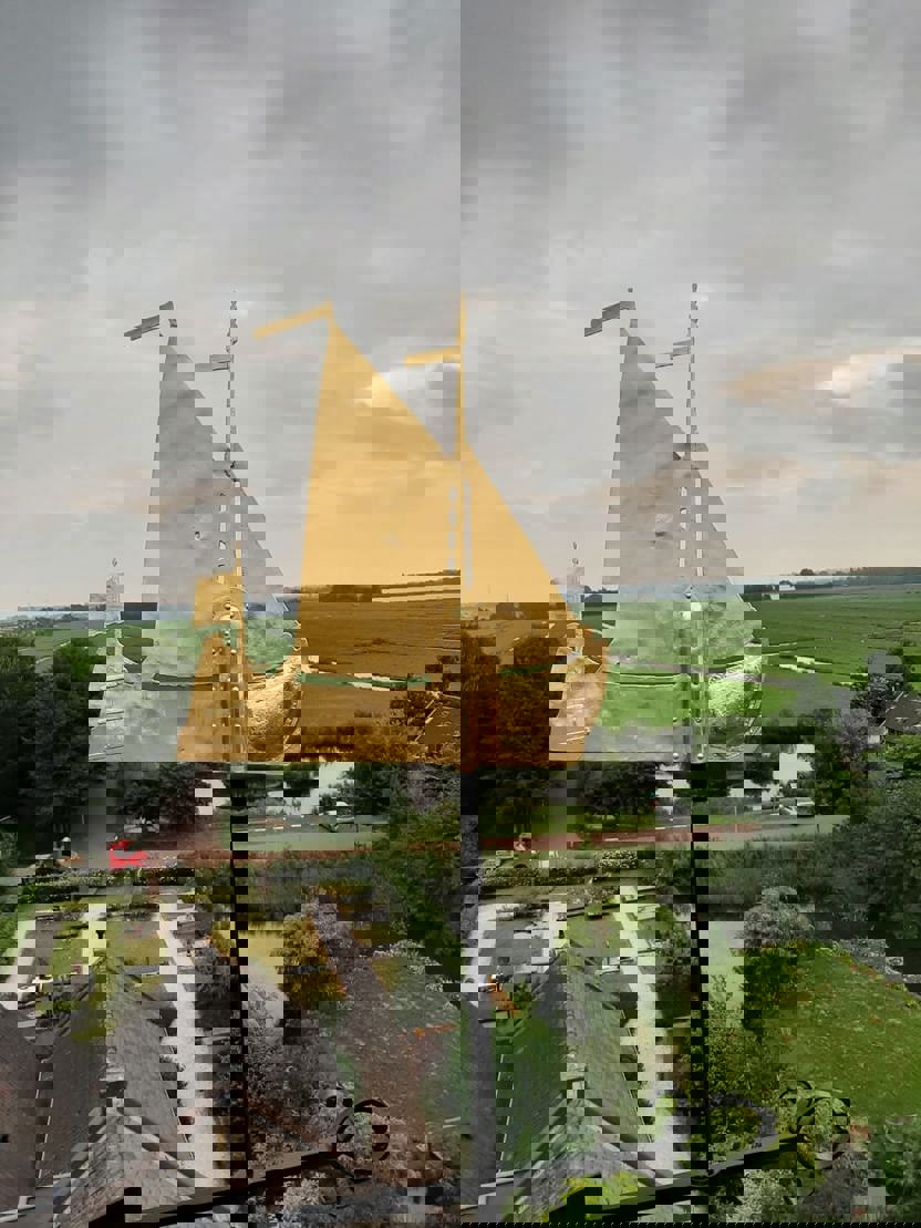 Gouden windwijzer in de vorm van een schip.