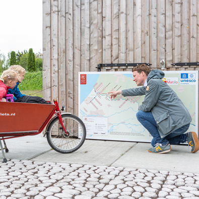 Kaart met plekken langs de limes, vader met kinderen kijken ernaar
