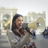 Vrouw verspreidt een boodschap met een megafoon
