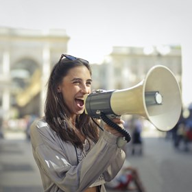 Vrouw verspreidt een boodschap met een megafoon