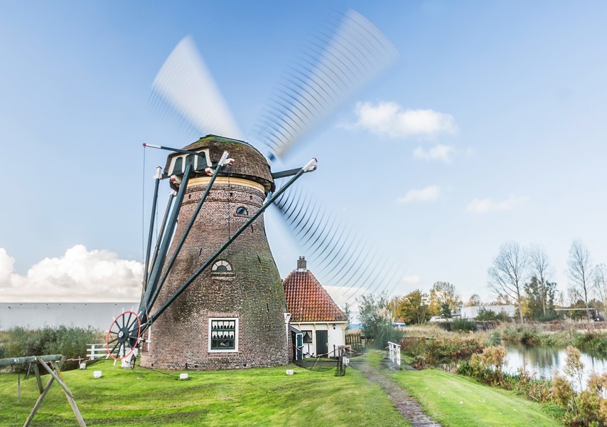 Stadsmolen in Leiden met wit molenaarshuisje en water ernaast