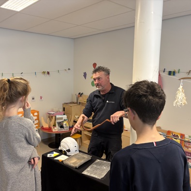 Foto van monumentenwachter die iets aan de kinderen vertelt