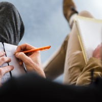 Man maakt aantekeningen in notitieboekje