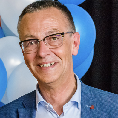 portretfoto van man met bril en blauw jasje