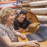 Twee personen zitten achter een laptop